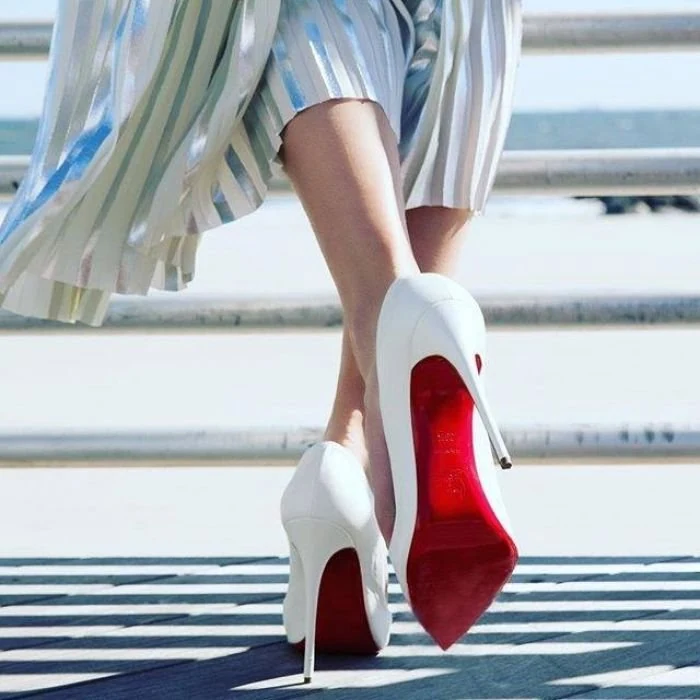 White high heels with red soles worn outdoors