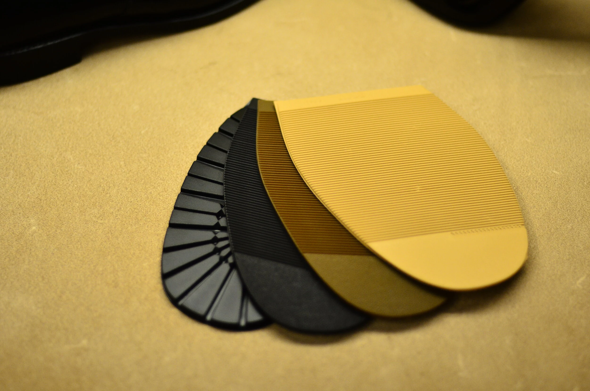 Black and beige Vibram and Topy rubber half soles with different tread patterns