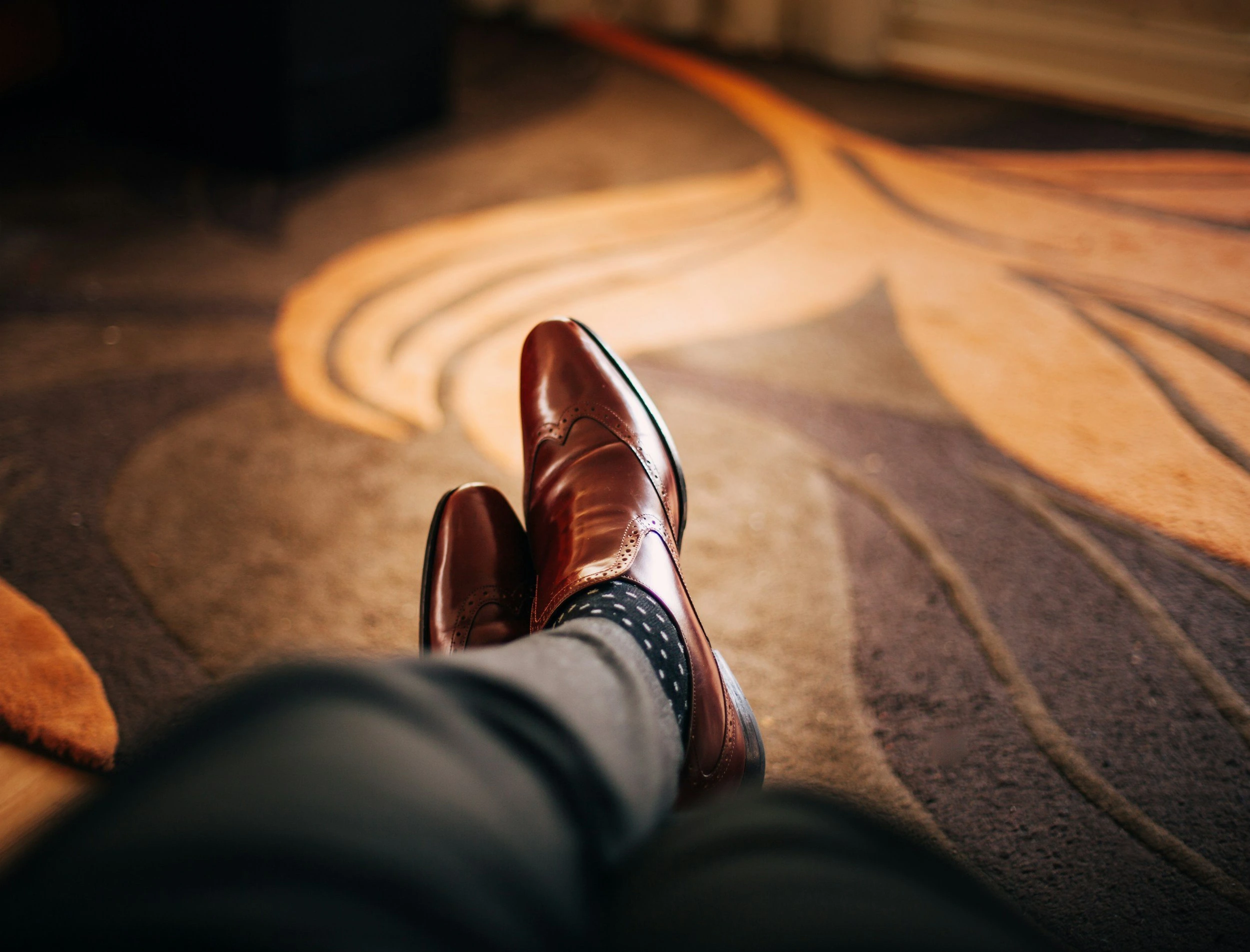 Polished brown leather dress shoes worn with patterned socks